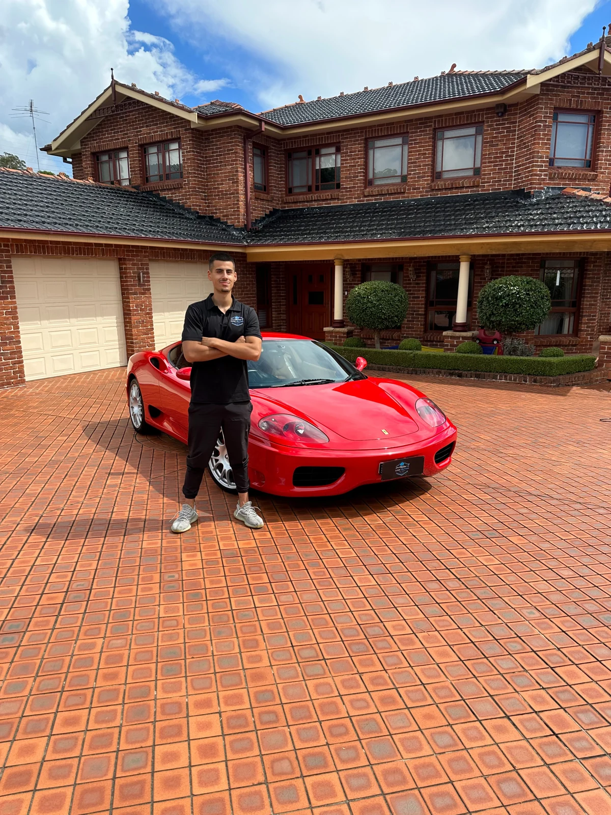 Lynx Autos portrait beside a red Ferrari