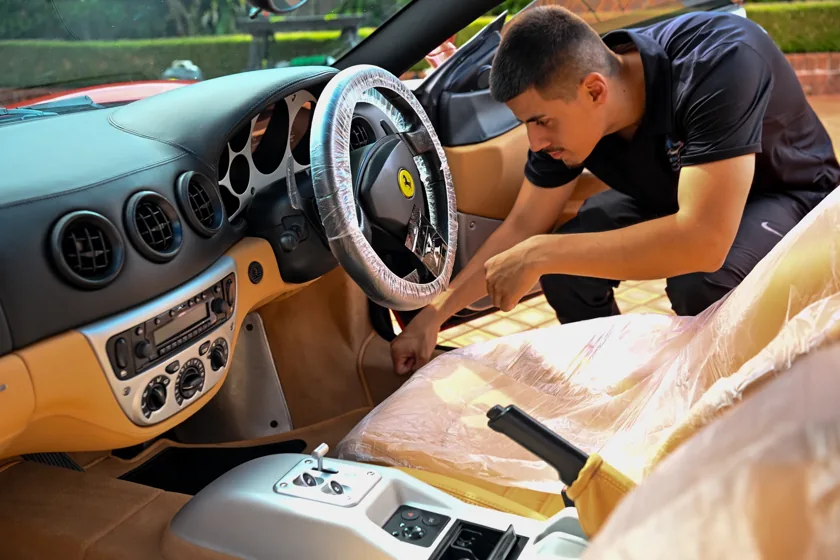 Victor carefully detailing a Ferrari interior